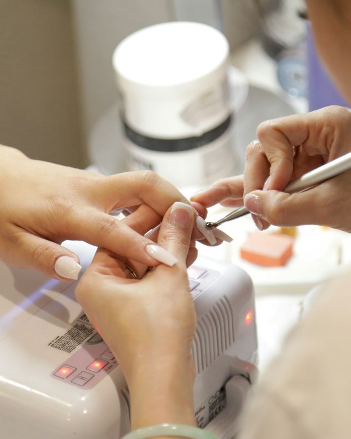 Nail technician shaping a client's nails
